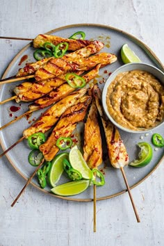 chicken skewers with dipping sauce on a plate