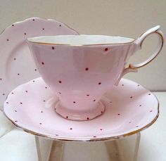 two pink cups and saucers sitting on top of each other