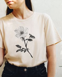 a woman wearing a t - shirt with flowers on it