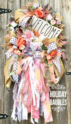 a welcome sign hanging from the side of a wooden fence with flowers and ribbons around it