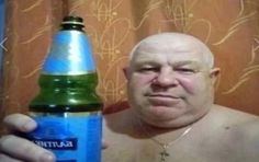 a bald man holding up a blue bottle