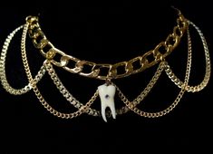 13 " 24 k gold or rhodium plated stainless steel curb chain choker featuring a resin replica human toothcharm embellished with swarovski crystals. 2" adjustable length Tooth Necklace Aesthetic, Christian Goth, Tooth Charm, Necklace Aesthetic, Edgy Jewelry, Tooth Necklace, Richmond Hill, Chain Choker, Choker Necklaces