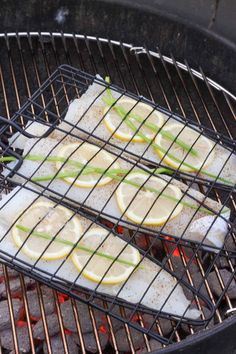 fish and lemons cooking on an outdoor grill