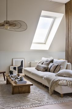 a living room filled with furniture and a skylight