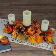 a table topped with candles and fall decorations