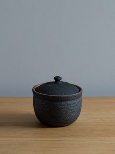 a black pot sitting on top of a wooden table