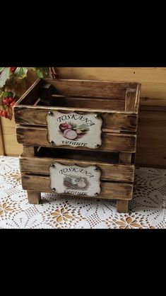 two wooden crates sitting on top of a white doily covered table next to a potted plant