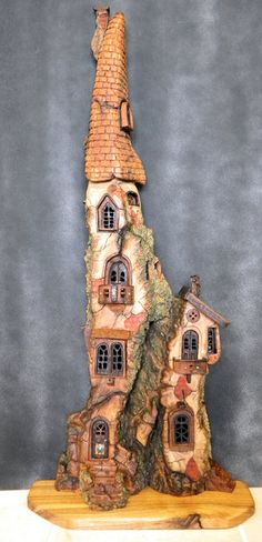 a statue of a house on top of a tree stump