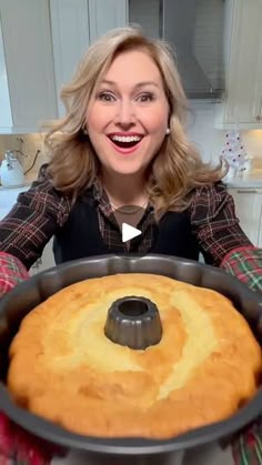 a woman holding a cake pan with a bundt cake in it's center