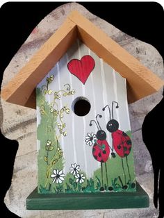 a birdhouse with ladybugs painted on it