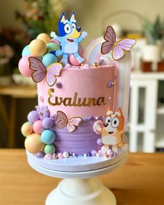 there is a pink cake with purple frosting and decorations on the top that says evaluna