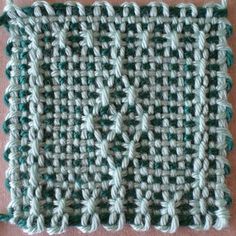 a crocheted square with green and white yarn