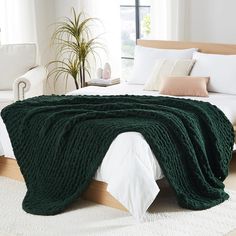 a large green blanket on top of a bed