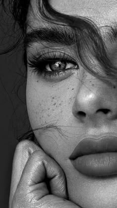 a woman with freckled hair is posing for a black and white photo while holding her hand to her face