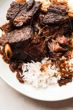 a white plate topped with meat and rice