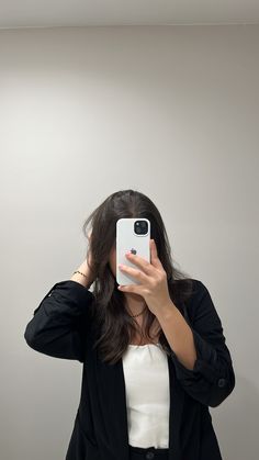 a woman taking a selfie in front of a mirror with her cell phone up to her face