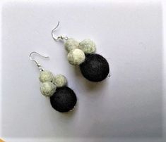 two black and white balls are hanging from earrings