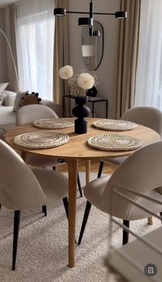 a dining room table and chairs with plates on them in front of a couches