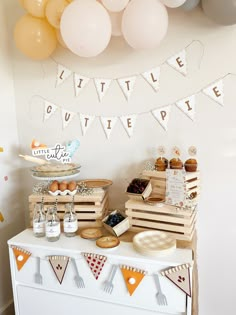 a table topped with lots of food and balloons