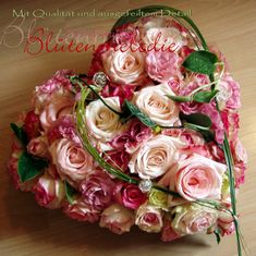 a bouquet of pink and white flowers on a wooden table with the words blieenvelie written in german