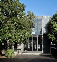 the entrance to an apartment building with trees in front