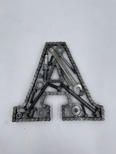 a letter made out of chains and wrenches