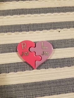 a pink heart shaped puzzle with the word love spelled in two letters on top of it