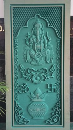 a green statue sitting on top of a cement slab in front of a planter