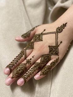 a woman's hand with henna tattoos on it