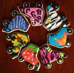 six decorated cookies arranged in the shape of fish and turtle on top of a wooden table