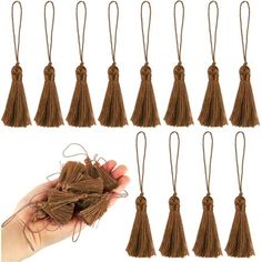 a hand holding a bunch of brown tassels