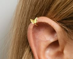 a woman's ear with a tiny yellow butterfly on it