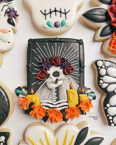 decorated sugar cookies arranged in the shape of skulls and flowers on a white tablecloth