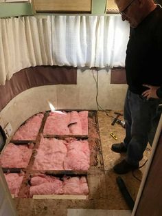 a man standing next to a pile of meat in a room with no one around