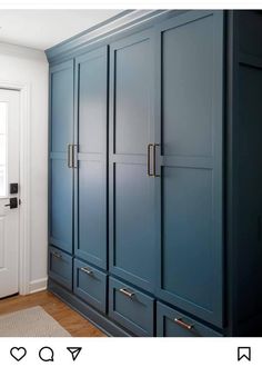 a blue armoire in a white room with wood flooring and wooden door handles