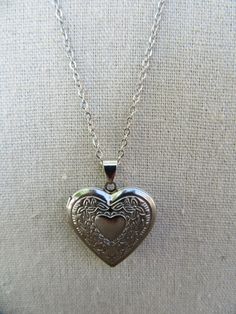 90s silver tone chain with heart locket. Lobster claw closure. Lightweight, costume jewelry. Very cute.  Chain is 20" Locket opens and closes and measures 1-1/8" x 1-1/8" Some light scuffing on underside, otherwise good with no other noted flaws. Metal Heart Necklace With Lobster Clasp, Vintage Silver Heart Pendant Charm Necklaces, Vintage Silver Charm Necklace With Heart Pendant, Vintage Silver Heart Pendant Charm Necklace, Vintage Metal Heart Locket Necklace, Vintage Heart Locket Necklace Nickel Free, Vintage Nickel-free Heart Pendant Charm Necklace, Vintage Metal Heart Necklace Nickel Free, Metal Heart Pendant Locket Charm Necklace