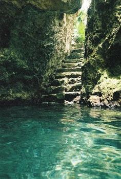 the water is crystal blue and clear in this photo, with steps leading up to it