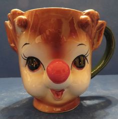 a close up of a ceramic cup with a clown face on it's side