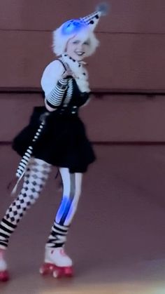 a woman in black and white dress holding a cell phone up to her ear while standing on roller skates