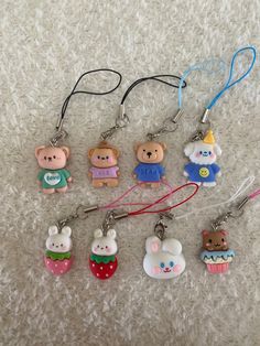 several keychains with cartoon characters on them sitting on a white carpet next to each other