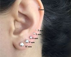 an ear with three different types of piercings on the top and bottom of it