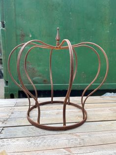 a metal pumpkin shaped object sitting on top of a wooden table