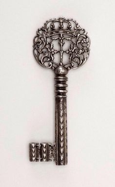 an ornate key is shown on a white surface