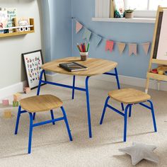 two children's chairs and a table in a child's room with blue walls