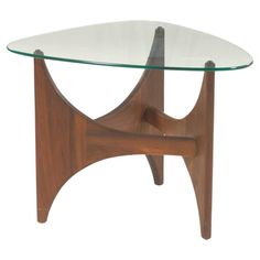 a glass and wood coffee table with an unusual design on the top, against a white background