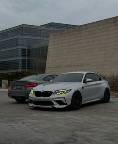 two cars parked next to each other in front of a building