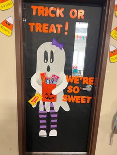 a door decorated to look like a ghost with candy in its hands and the words trick or treat on it