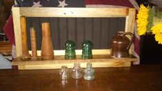 a wooden shelf with vases and other items on it next to an american flag