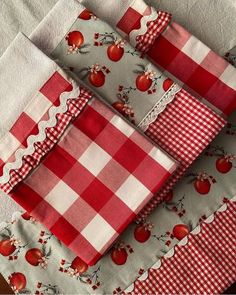 three red and white cloths with apples on them