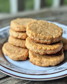 a stack of cookies sitting on top of a white plate next to a wooden table